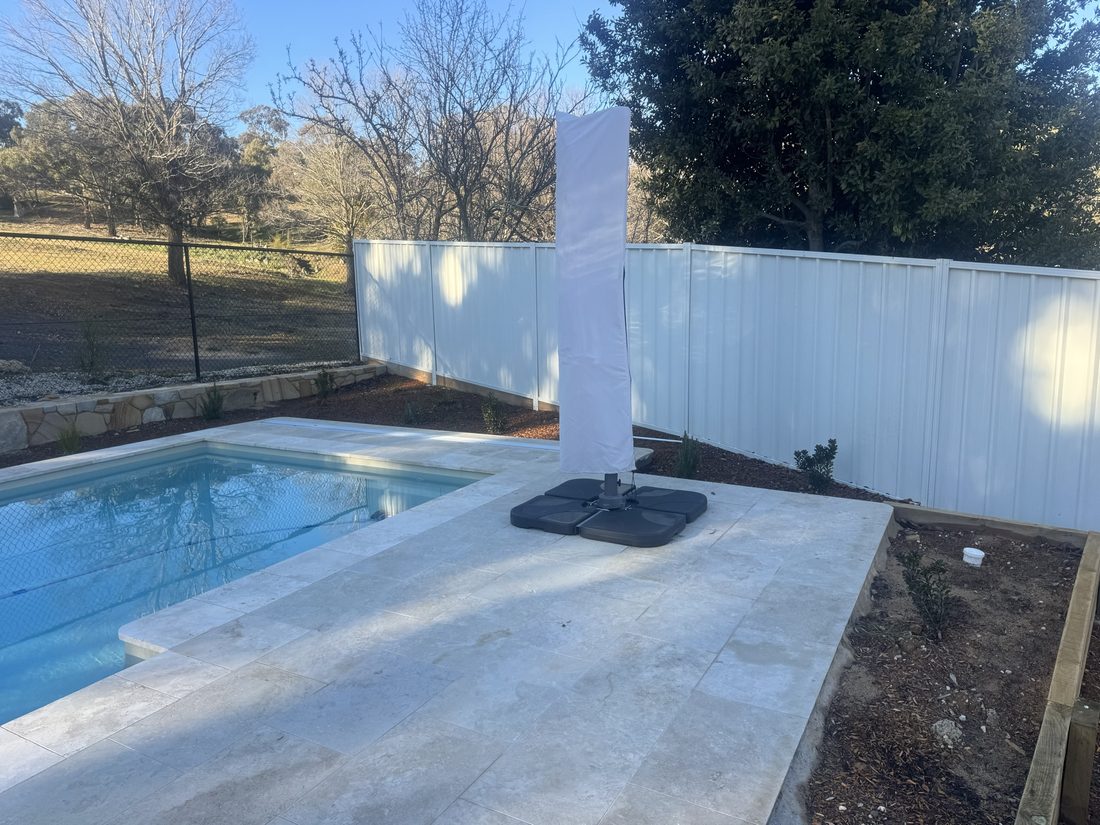 Pool with a Colorbond boundary fence and rural paddocks beyond