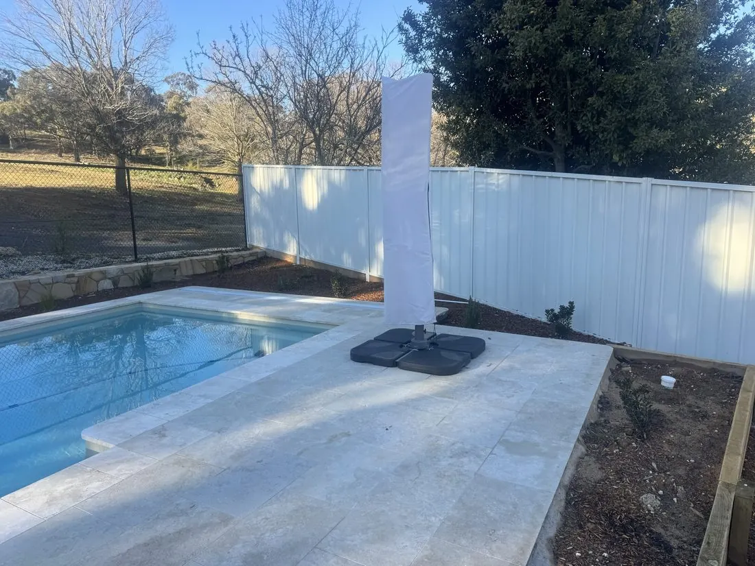 Pool with a Colorbond boundary fence and rural paddocks beyond